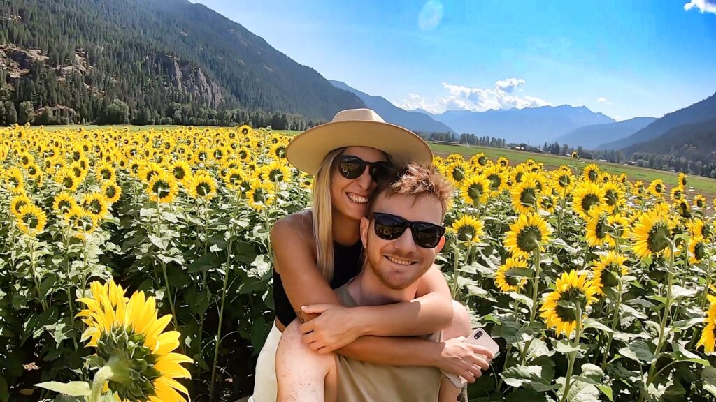 Couple smiling and together in a field of sunflowers