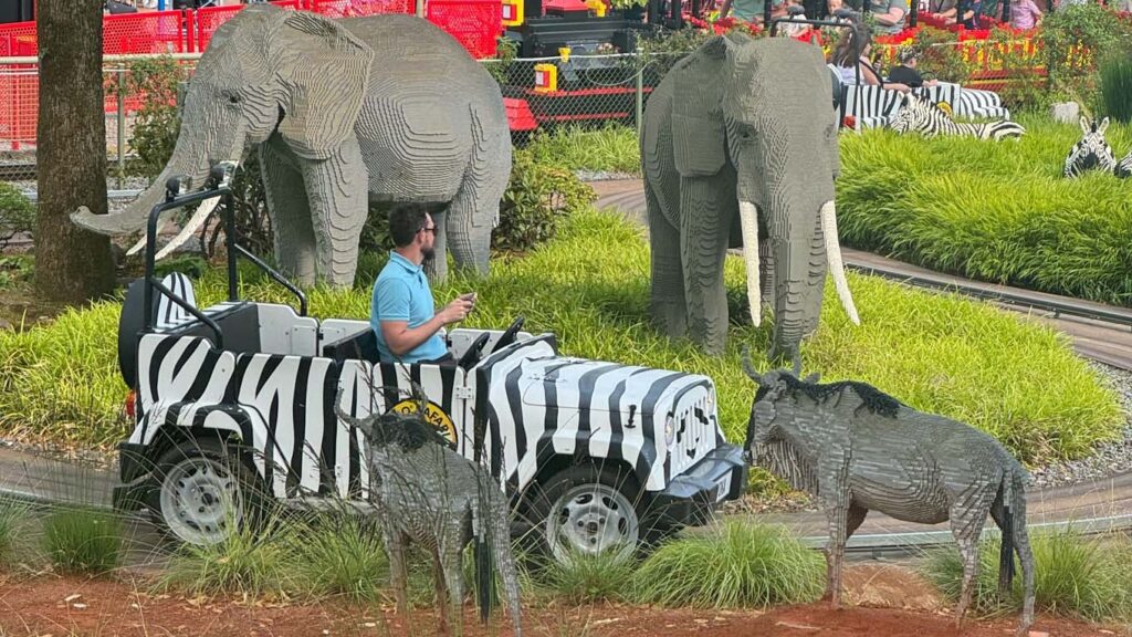 Man in a safari car on the lego safari attraction at Legoland Billund